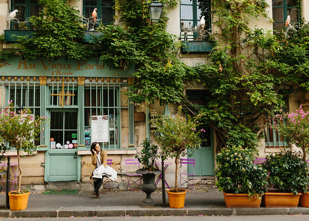 Vic sitting in front of Paris cafe